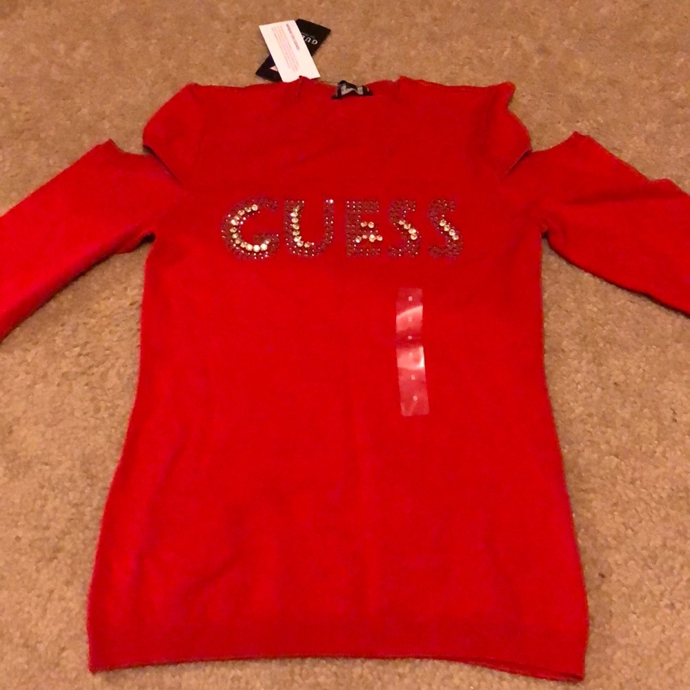 red, open-shouldered, long sleeve Guess shirt.